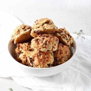 A bowl of French Onion Biscuits are shown on a white background