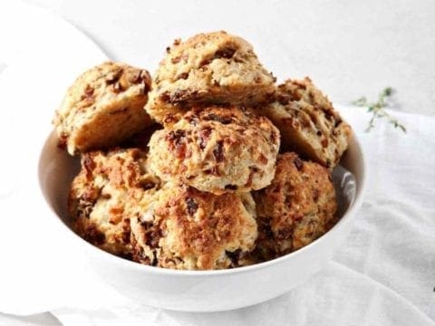 A bowl of French Onion Biscuits are shown on a white background