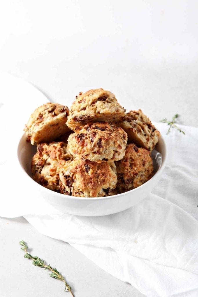 A bowl of French Onion Biscuits are shown on a white background