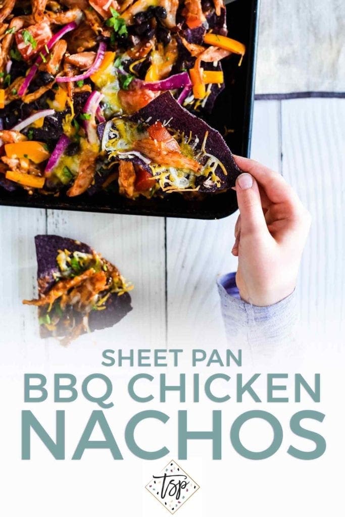 Pinterest image for Sheet Pan BBQ Chicken Nachos, featuring text and a girl reaching to grab a nacho from a full sheet pan