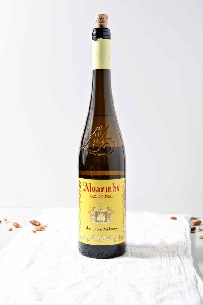 A bottle of Vinho Verde wine sits on a grey backdrop