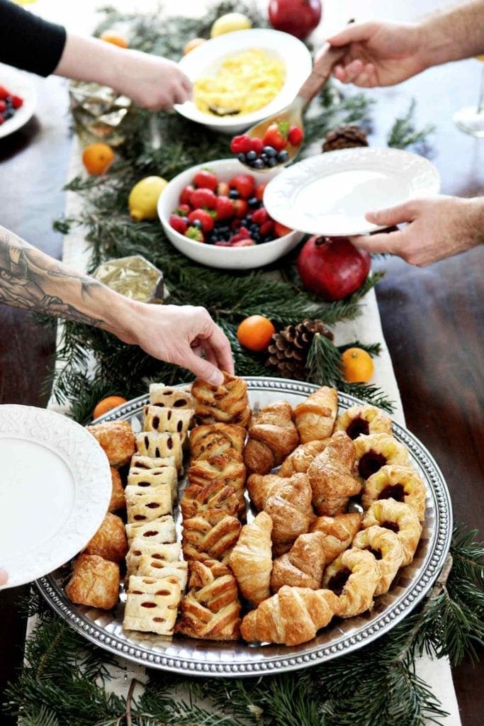 People serve themselves from the table at a holiday brunch