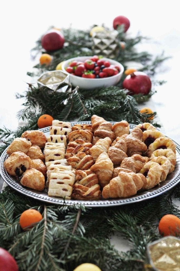 a tablescape with pastries, fruit and pine for an at-home brunch for the holidays