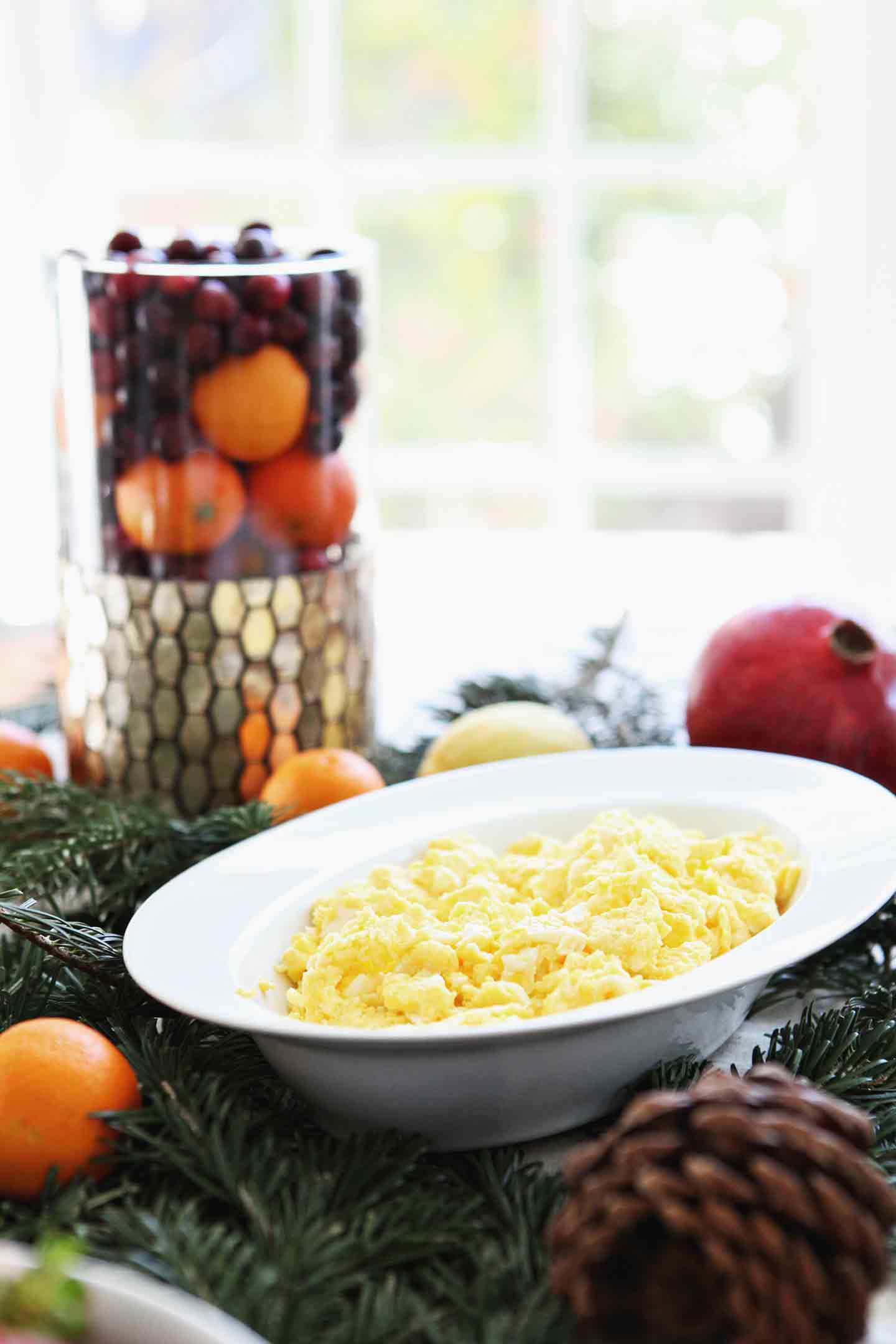 Scrambled eggs are served in a white dish on a holiday brunch table