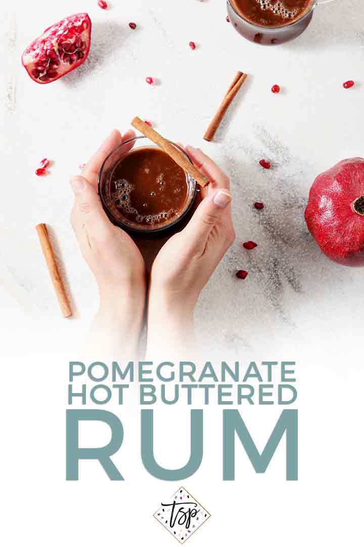 A woman holds a mug of Pomegranate Hot Buttered Rum in this Pinterest graphic