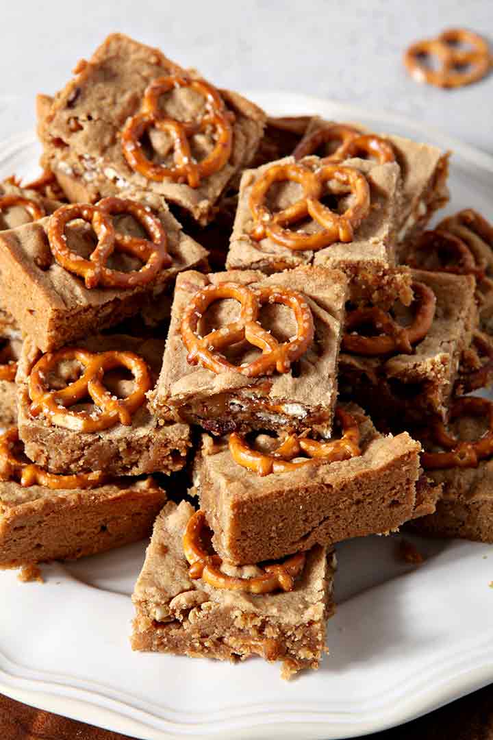 Close up of Boozy Bacon Pretzel Peanut Butter Bars on a white plate