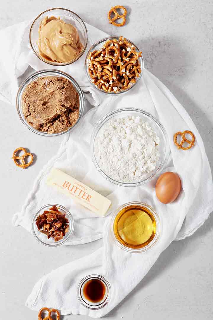 Ingredients for Boozy Bacon Pretzel Peanut Butter Bars are laid out on a towel