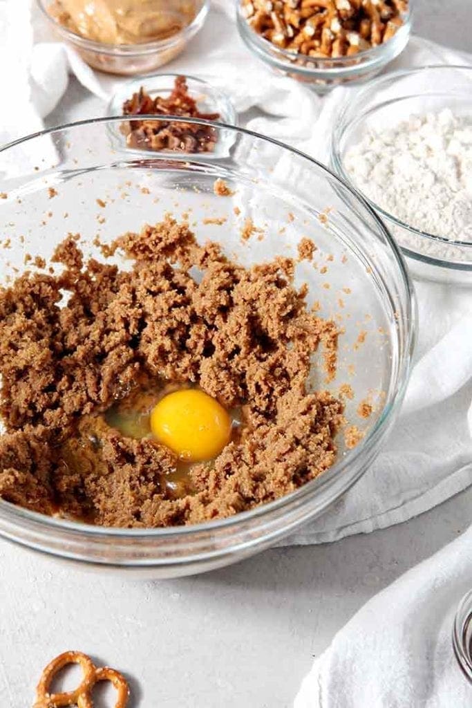 An egg is added into the batter of Boozy Bacon Pretzel Peanut Butter Bars