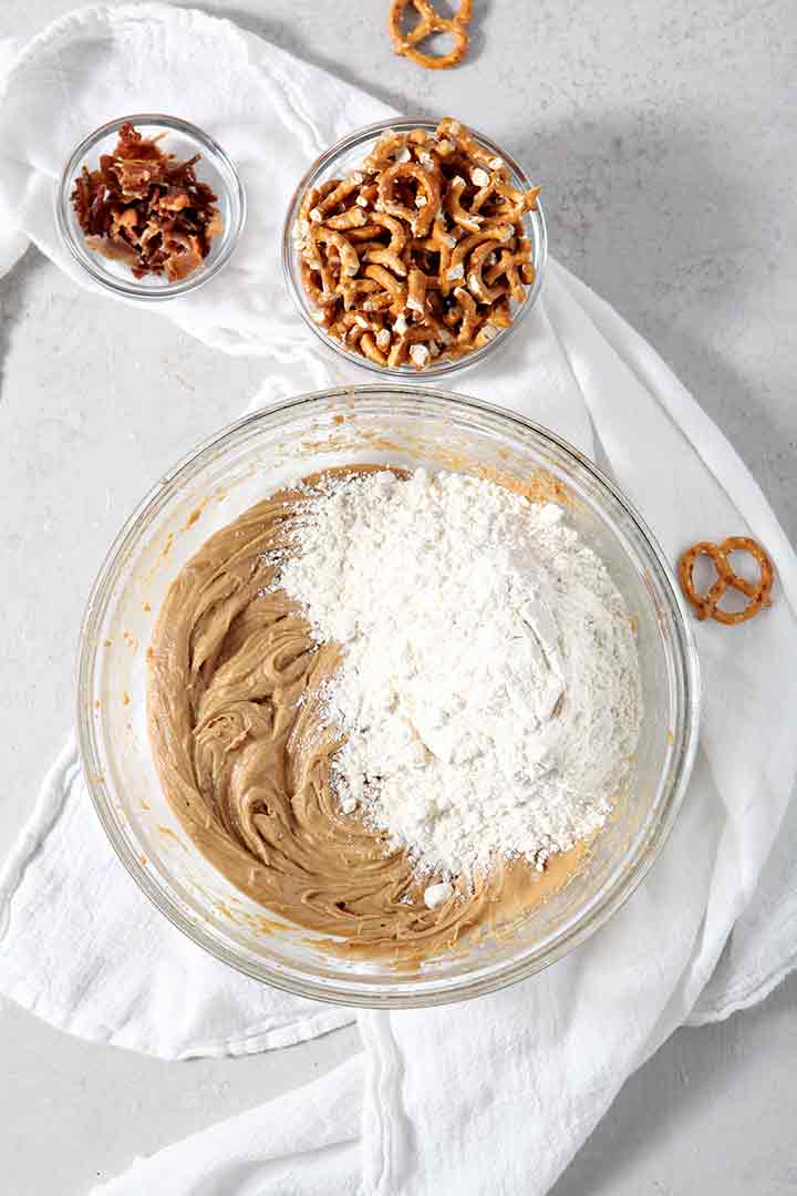 Flour is added to the batter of Boozy Bacon Pretzel Peanut Butter Bars