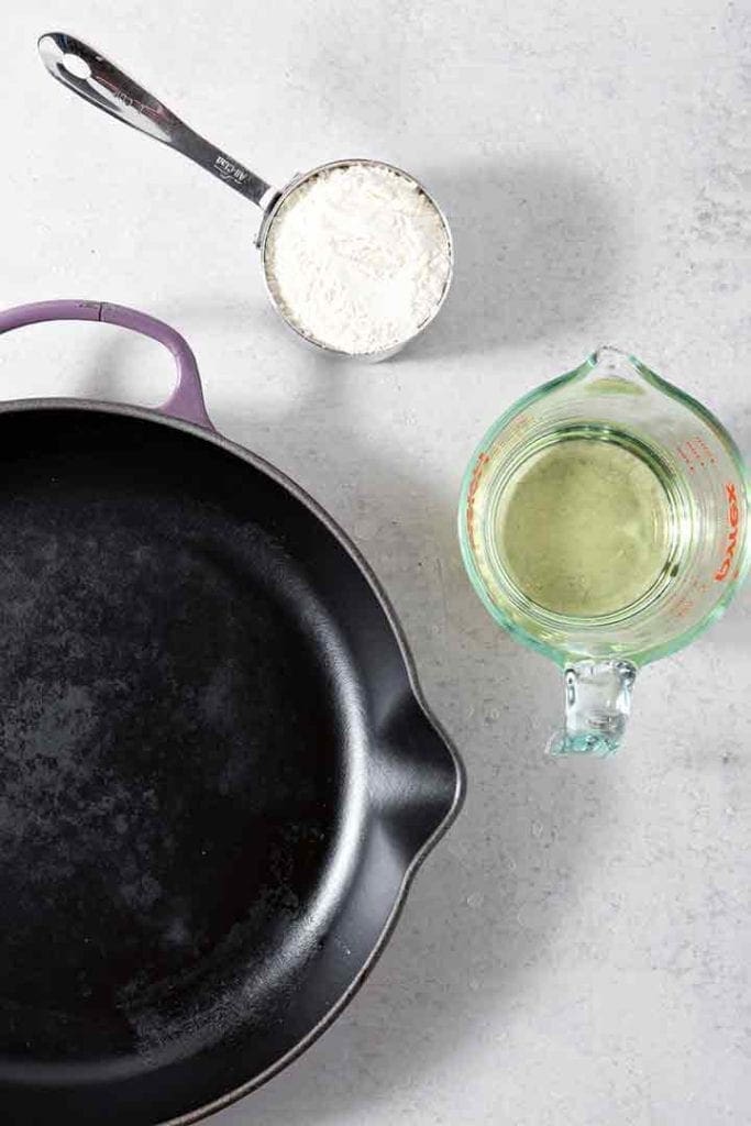 The ingredients and pan for a roux are shown on a grey background