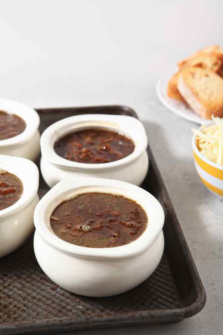 Crocks of soup before being dressed and broiled