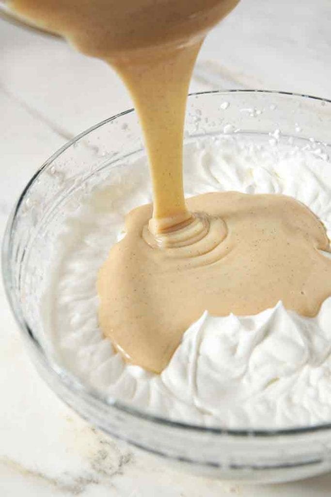 Sweetened condensed milk is poured into whipped cream