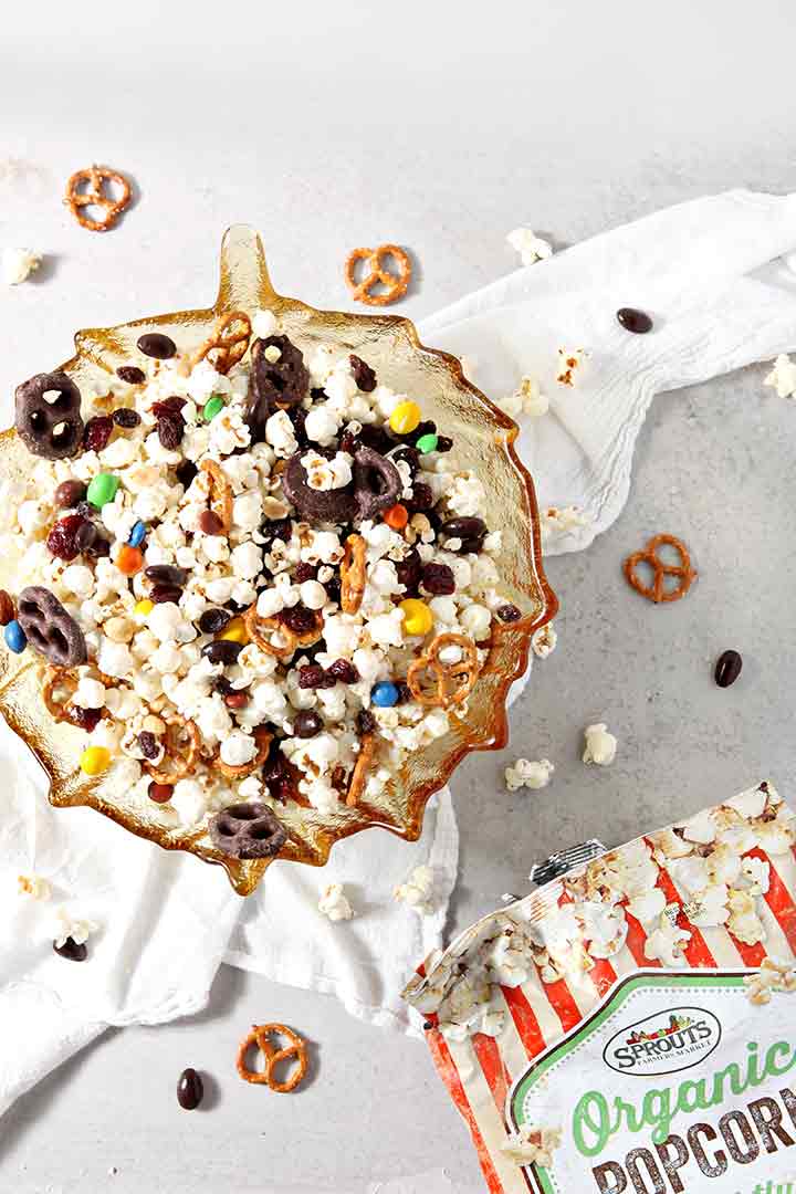 A large bowl of the popcorn snack mix recipe is shown with the popcorn bag