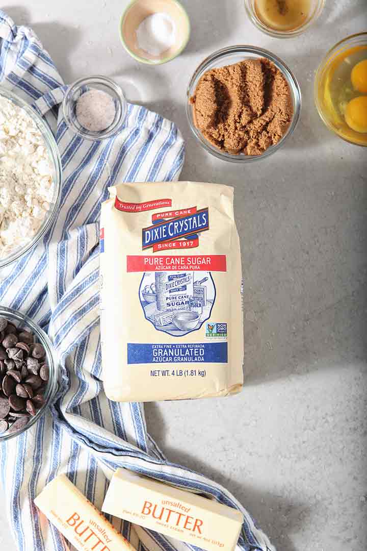 Ingredients to make Chocolate Chip Cookie Bars are laid out on a grey backdrop