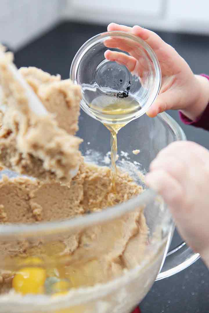 Vanilla is poured into the cookie bar batter