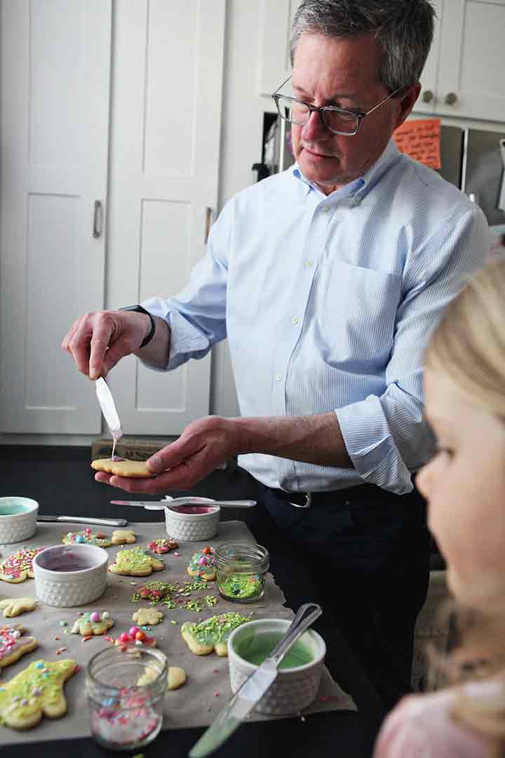 A man and a girl decorate Soft Lemon Tea Cakes in a kitchen