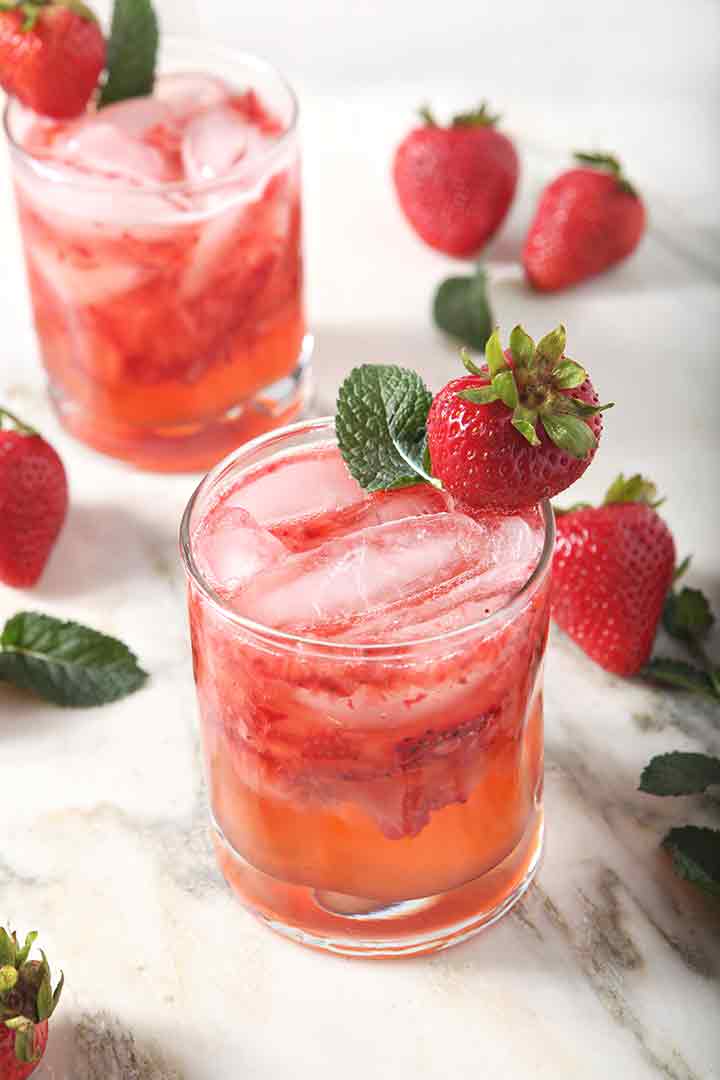 Two Strawberry Moscow Mules are served on a marble background