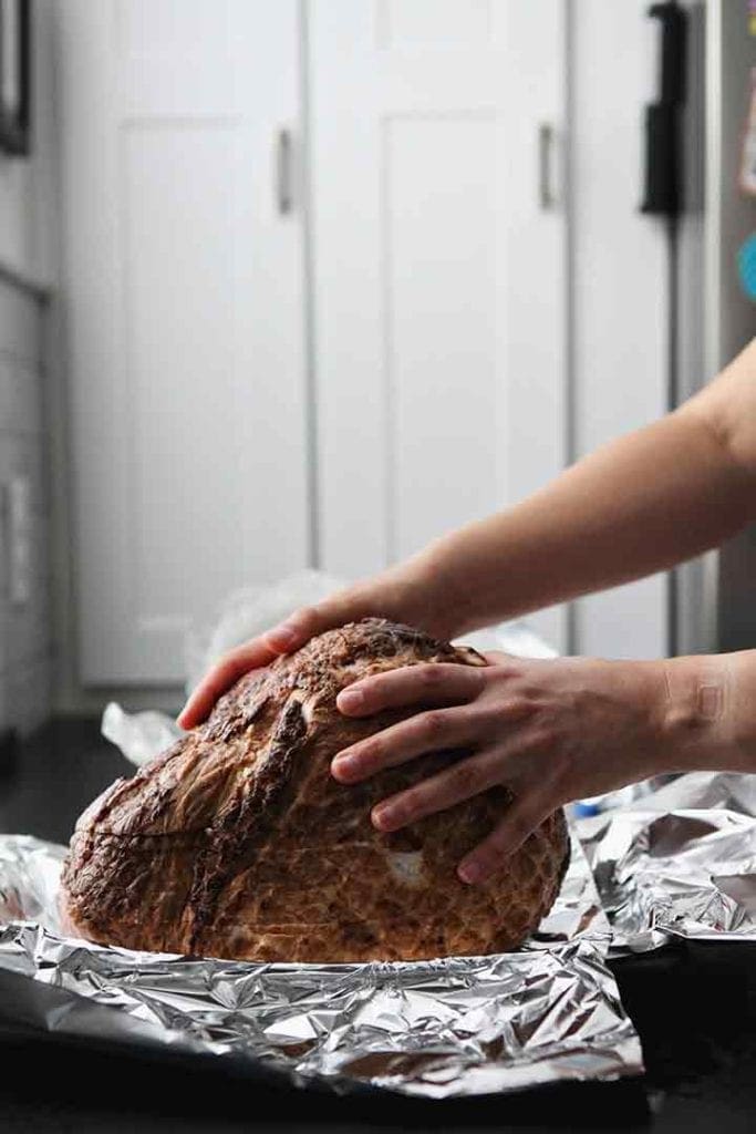 A woman prepares a spiral ham before baking