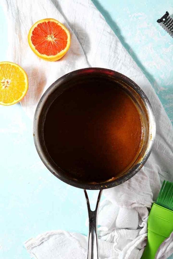 Bourbon orange glaze is shown in a saucepan before glazing a ham