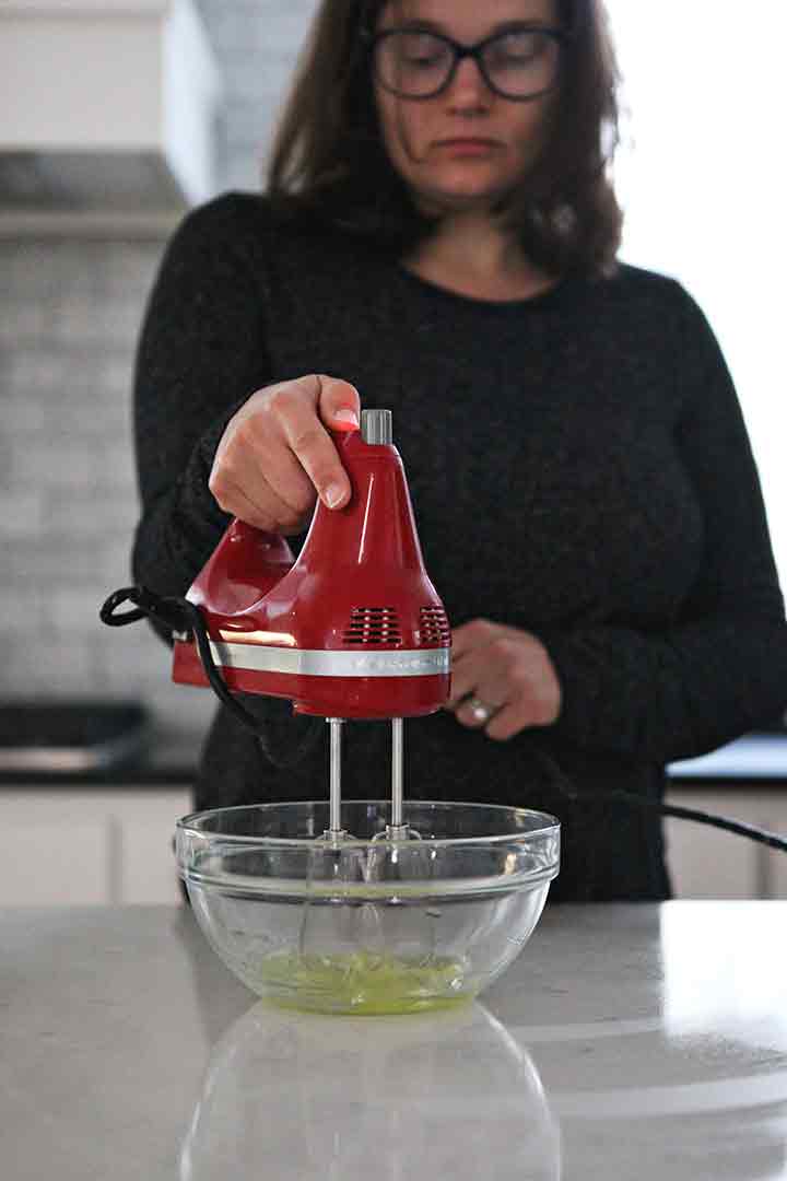 A woman whips egg whites to soft peaks