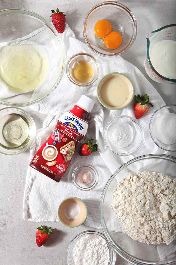 Strawberries and cream waffle ingredients are laid out on a flat surface