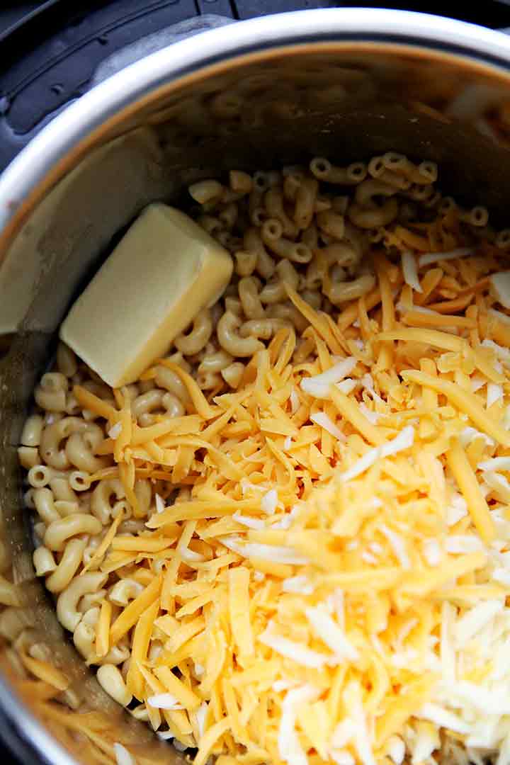 Cheese, butter and milk are added to the cooked macaroni to finish the macaroni and cheese in the Instant Pot