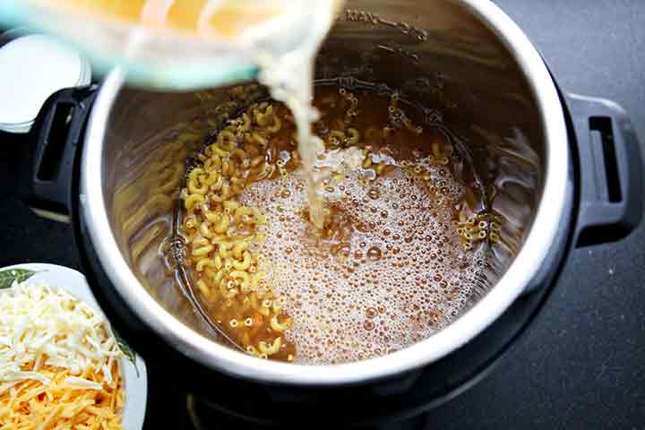 Ingredients for mac 'n cheese are poured into the Instant Pot before pressure cooking