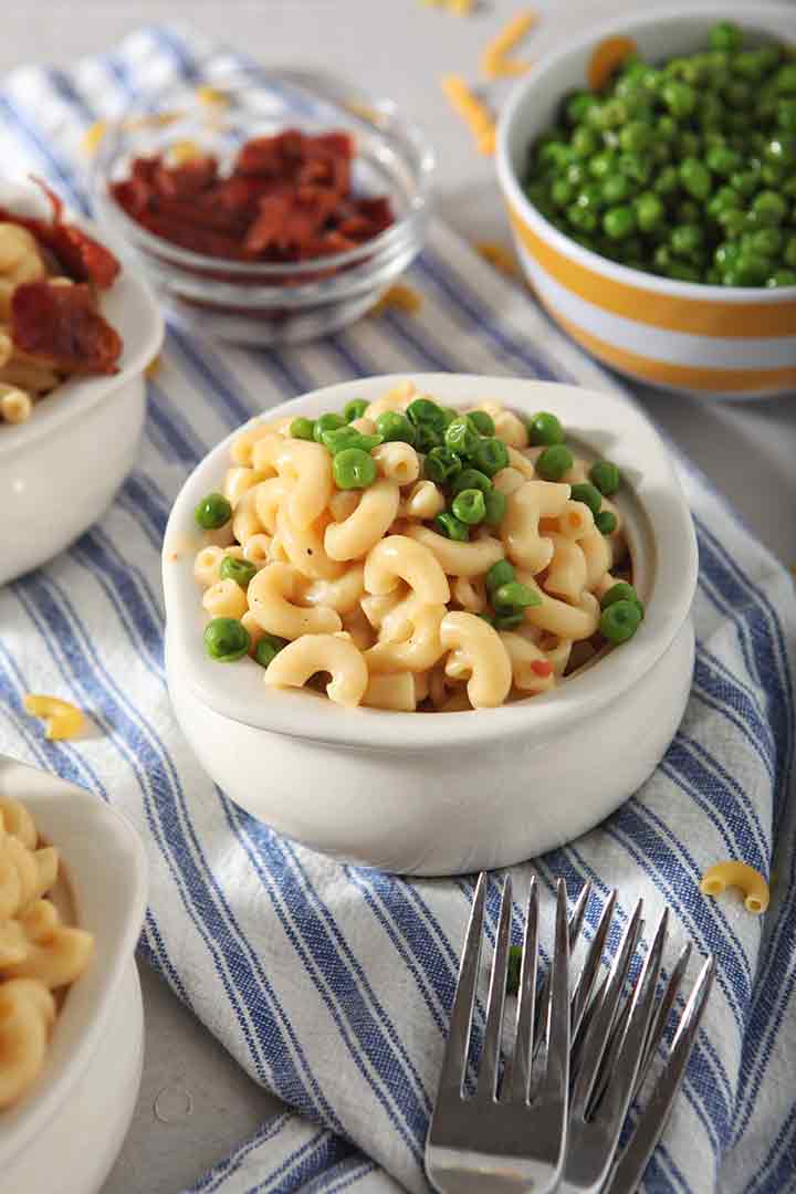 Close up of Instant Pot Macaroni and Cheese, served with steamed peas