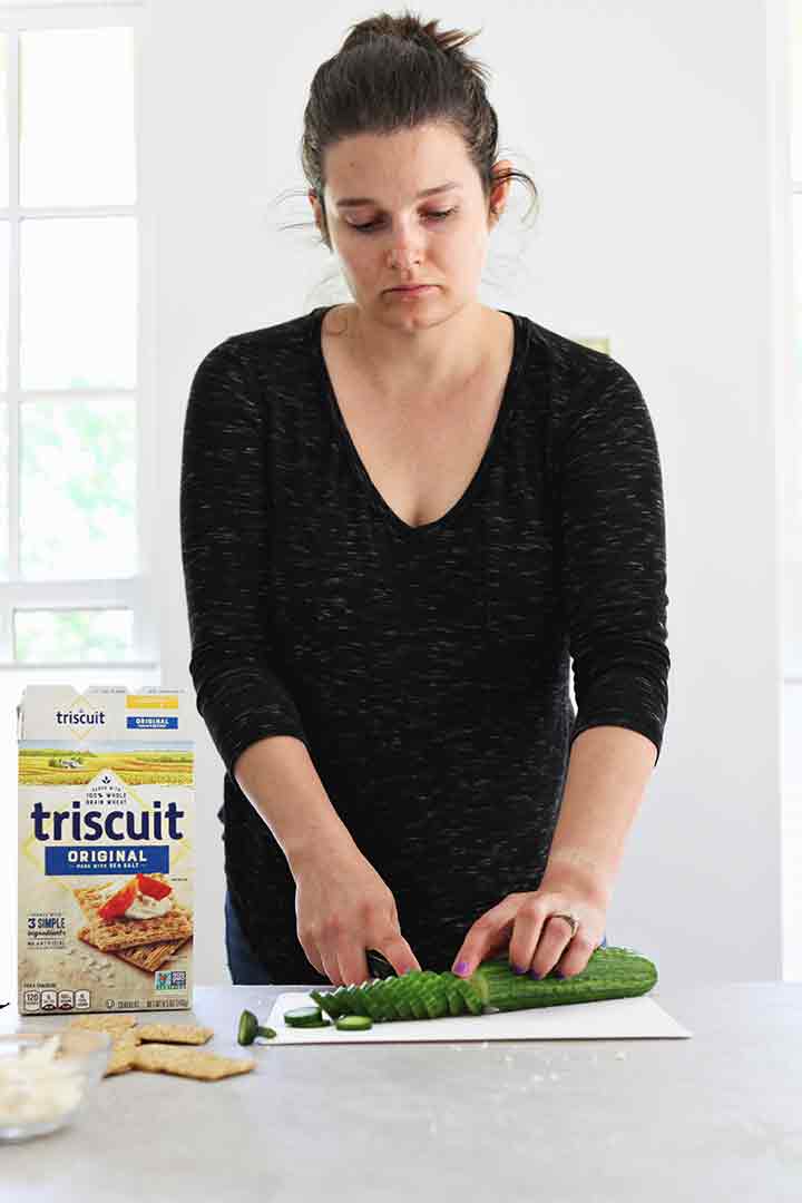 A woman chops an English cucumber