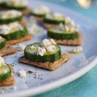 TRISCUIT Cucumber Bites are served on a white platter with white wine in the background