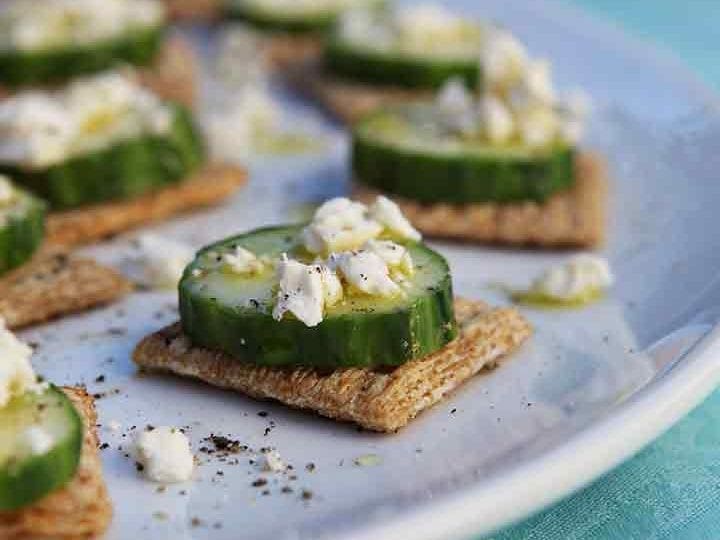 TRISCUIT Cucumber Bites are served on a white platter with white wine in the background