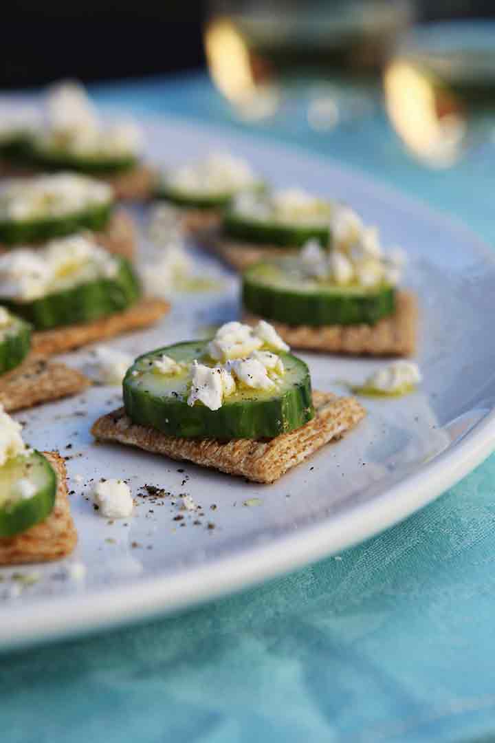 TRISCUIT Cucumber Bites are served on a white platter with white wine in the background