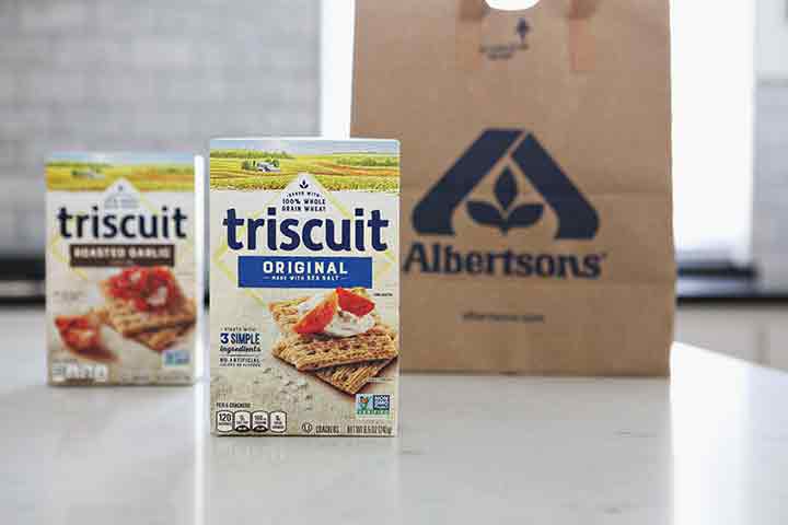 Two boxes of TRISCUIT Crackers stand in front of an Albertsons bag on a kitchen counter