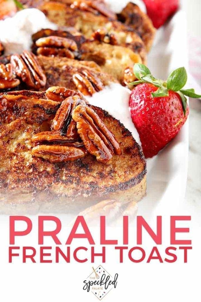 A close up of Praline French Toast with a fresh strawberry and Pinterest text