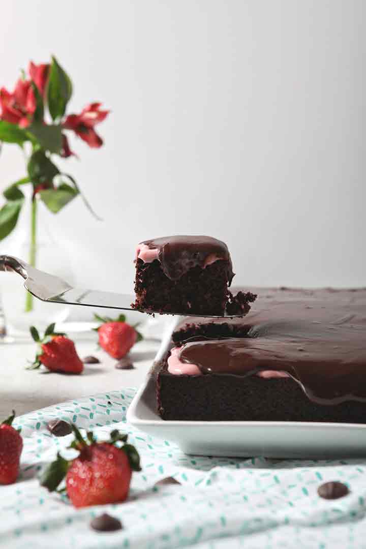 A slice of Strawberry Chocolate Cake is lifted out of the cake