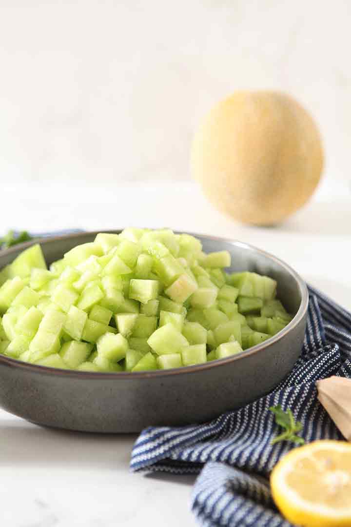 Diced melon is reserved in a bowl until it's time to mix the salad