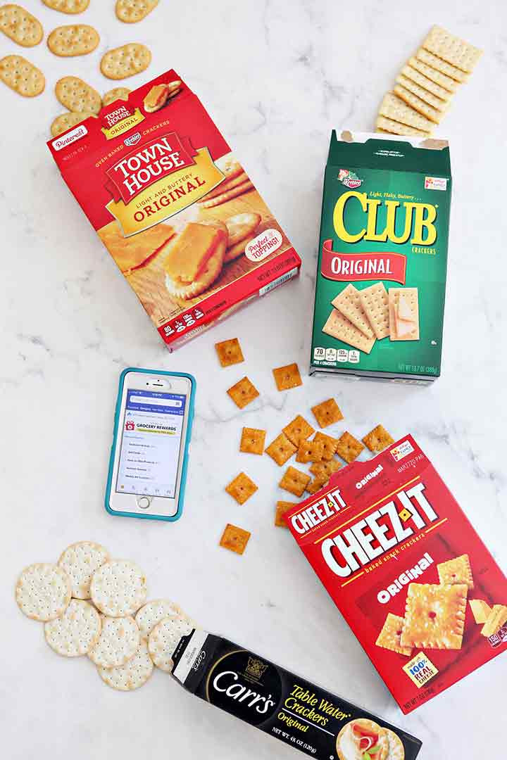 Crackers spill out of their boxes and are shown with a phone displaying the Albertsons app