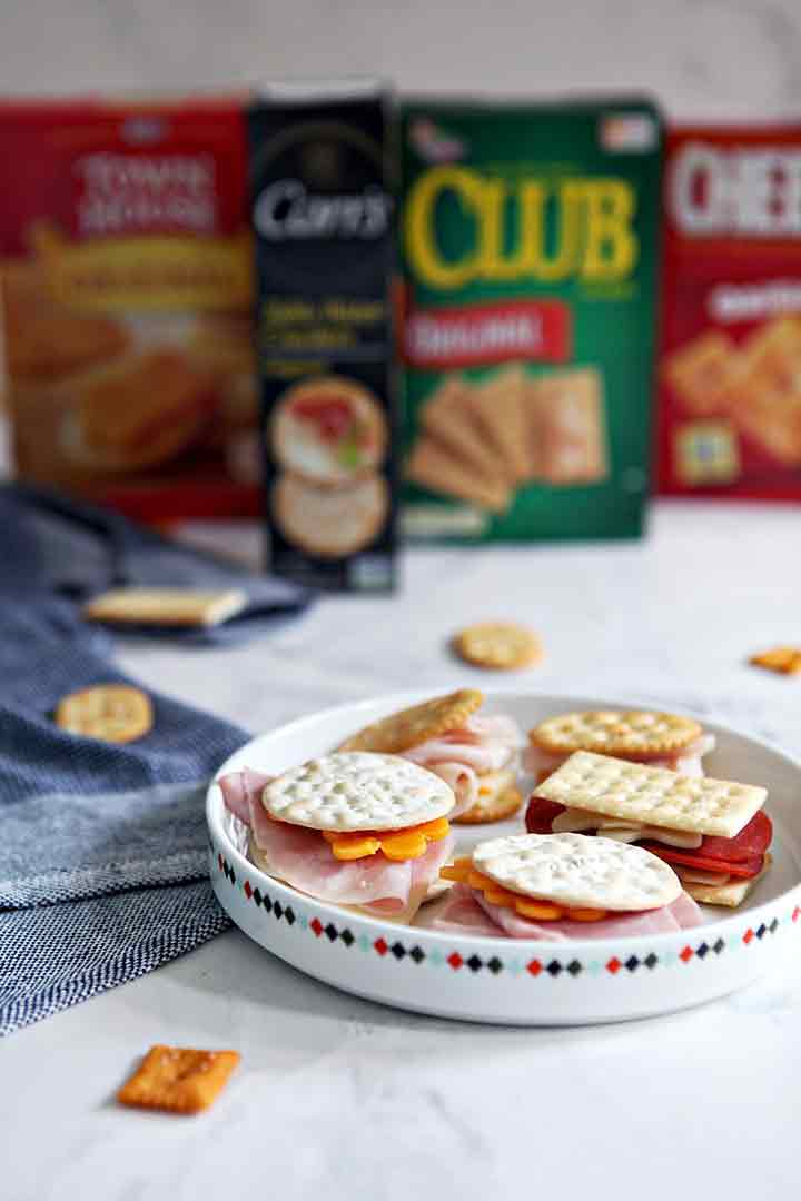 Cracker sandwiches are shown on a platter with cracker boxes in the background