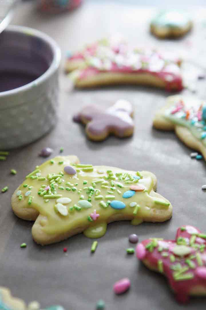 Close up of a sugar cookie decorated with Easy Lemon Icing and sprinkles