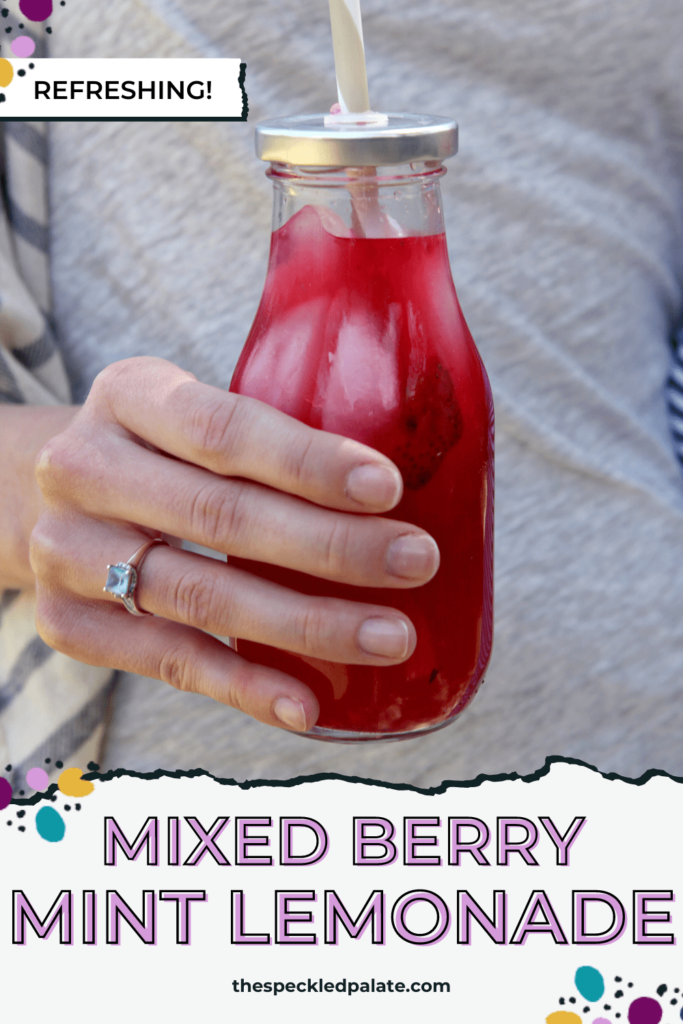 Hand holding glass jar with straw of a naturally sweetened pink lemonade with the text mixed berry mint lemonade