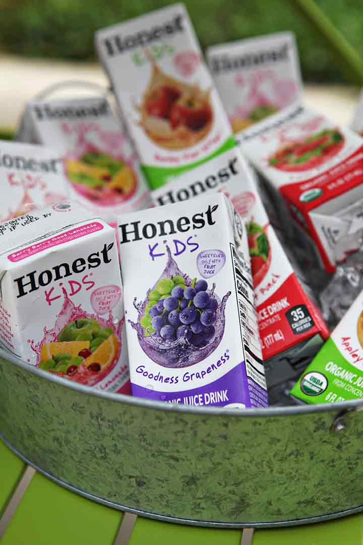 Honest Kids juice boxes are shown in a metal container on an outdoor bar cart