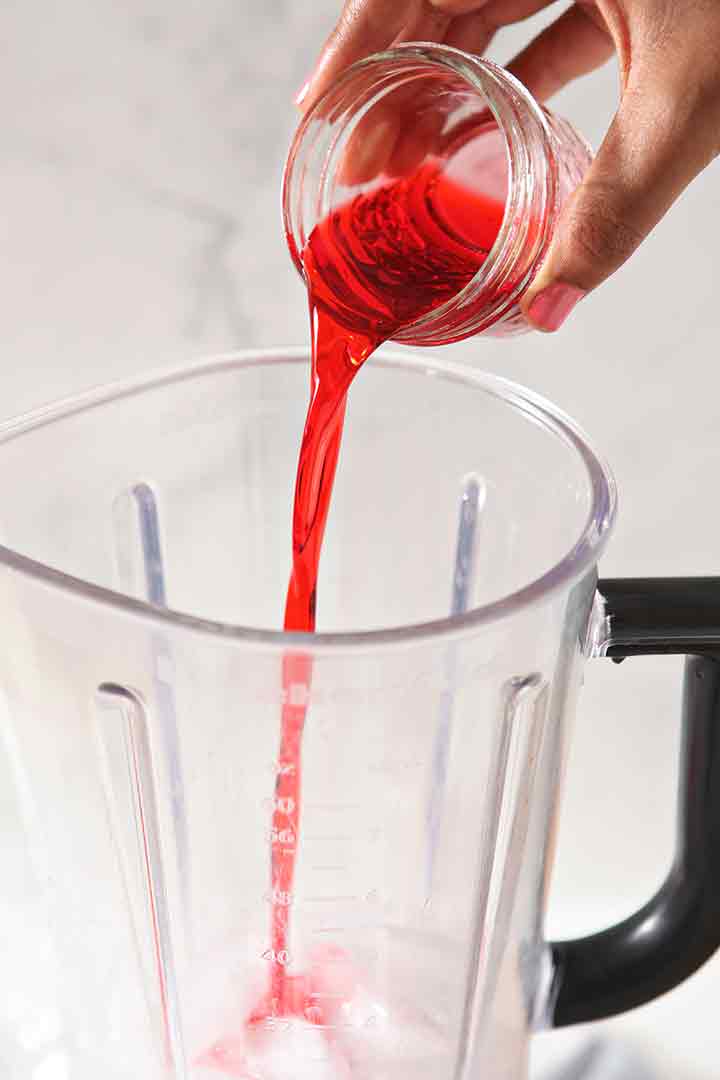 Cherry juice is poured into a blender