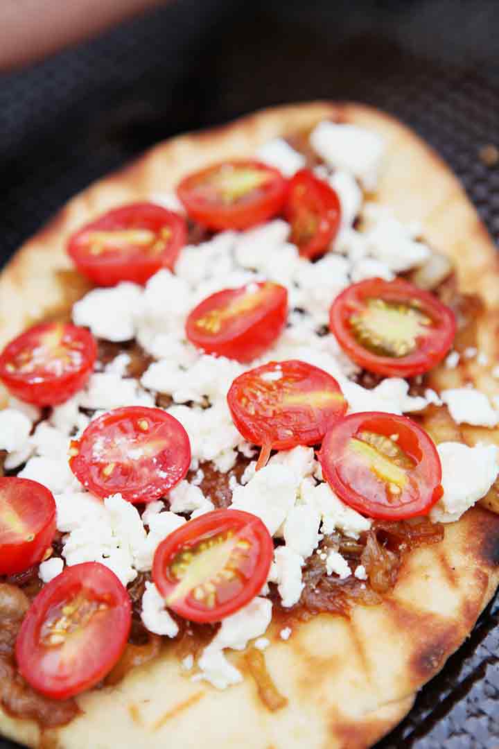 This grilled flatbread pizza recipe is shown on a baking sheet after coming off the grill