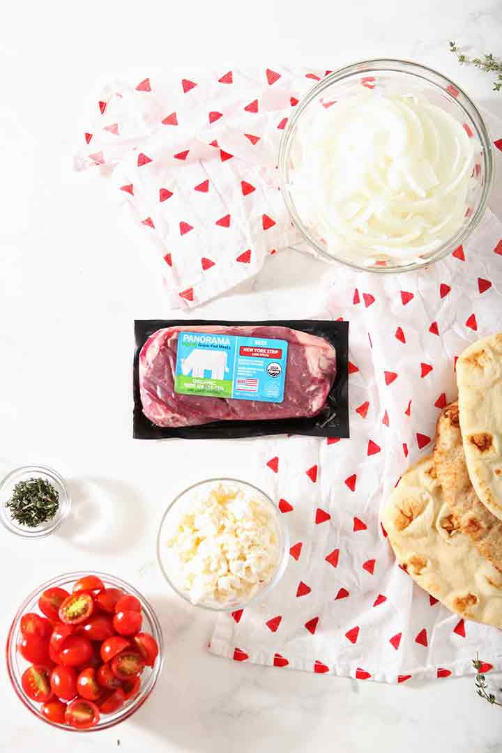 Ingredients for the grilled flatbread pizza dish are shown on a table before they are put together