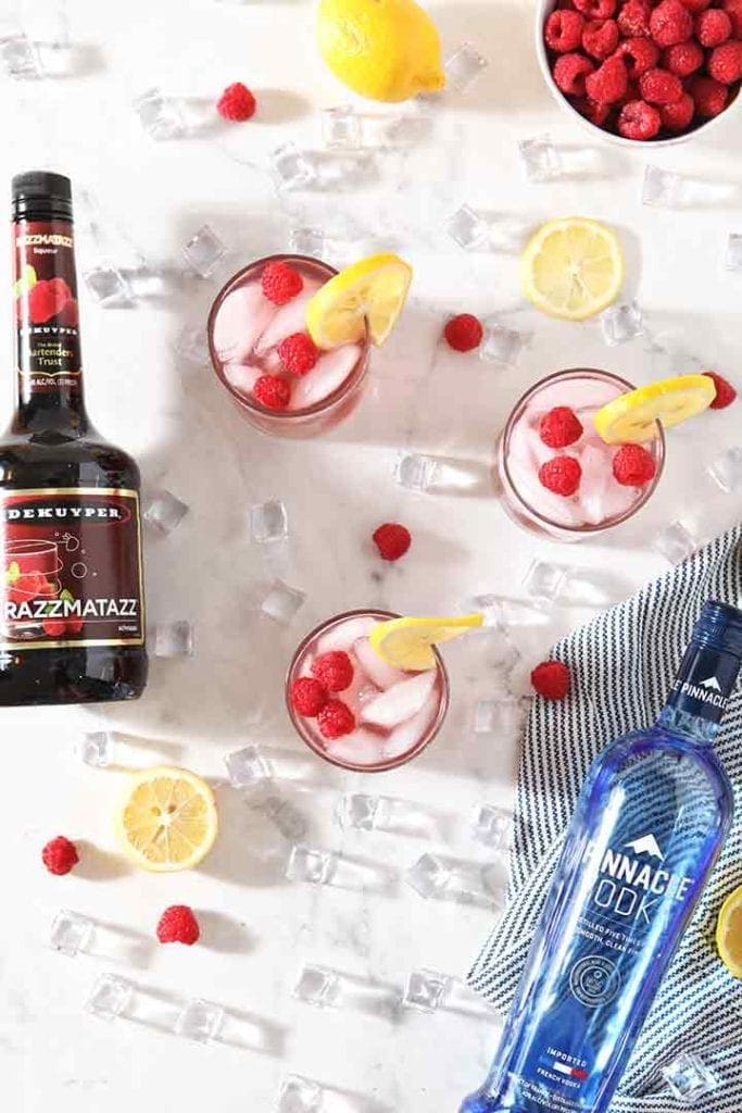 Vodka Lemonades with Raspberry from above, with the bottles of alcohol, and ice