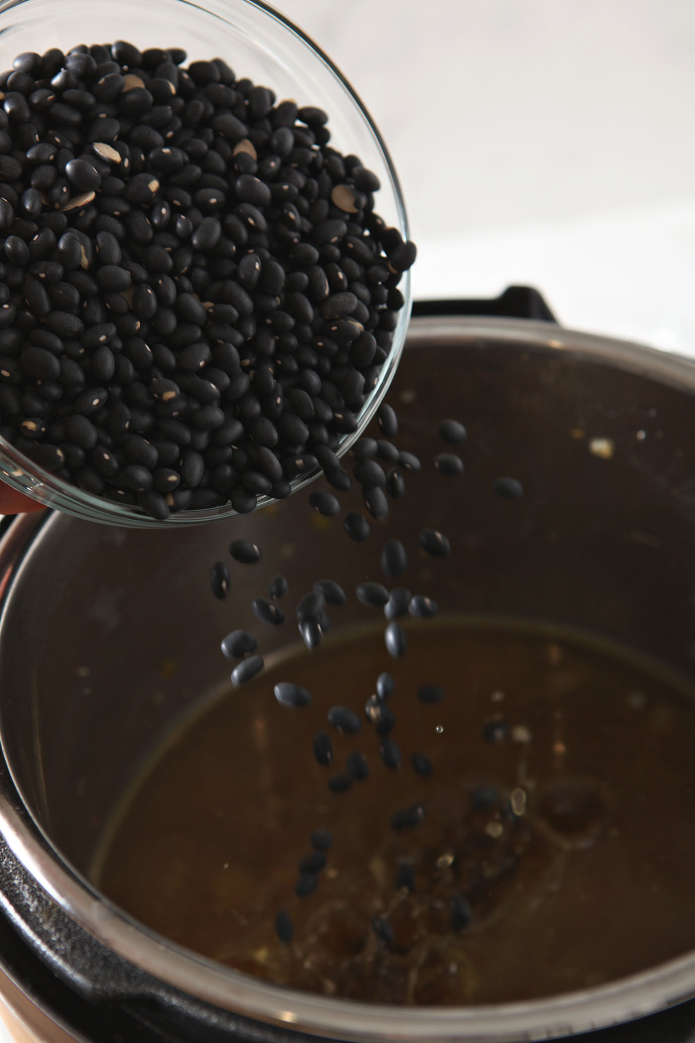 Dried black beans pour into an Instant Pot.