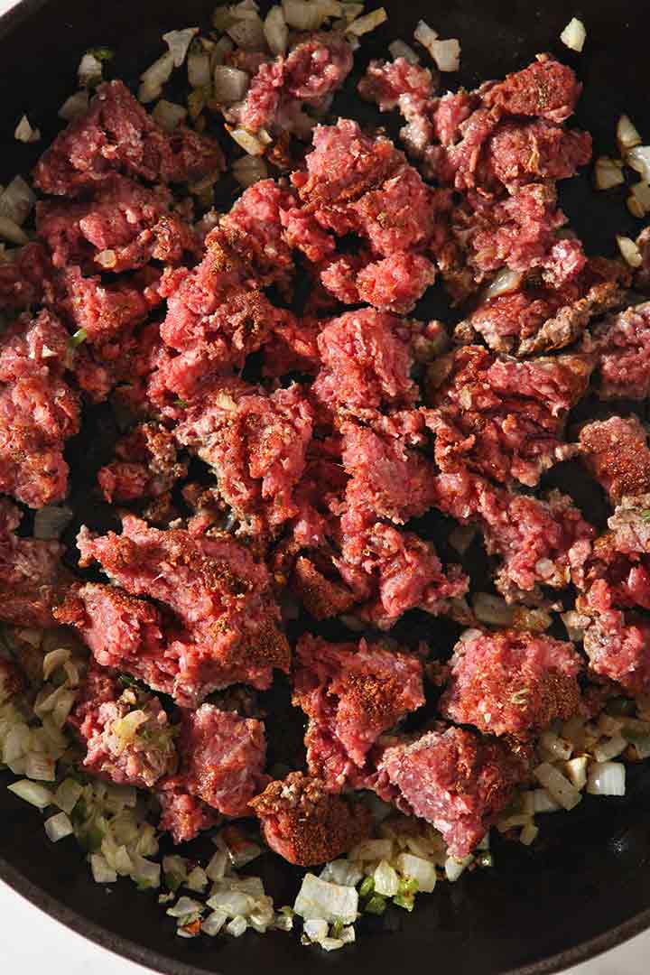 Close up of ground meat browning in a skillet, from above