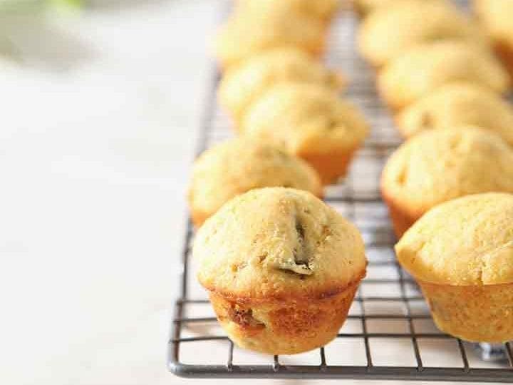 Several Hatch Chile Mini Cornbread Muffins are lined up on a cooling rack