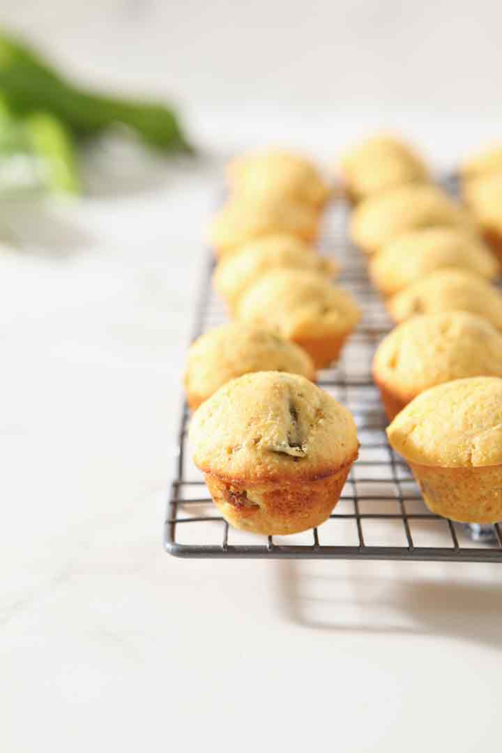 Several Hatch Chile Mini Cornbread Muffins are lined up on a cooling rack