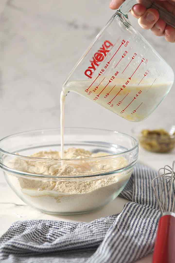 Wet ingredients are poured into dry ingredients as muffins are made